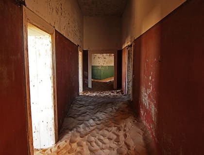 Flur mit Türen und Sand im Haus des Architekten