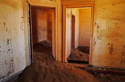 Flur im Arzthaus mit mehreren offenen Türen und Sand