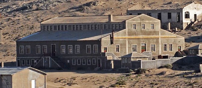 Das restaurierte Kasino von Kolmanskop mit heller Fassade unter blauem Himmel