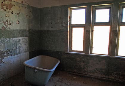 Badewanne in einem Raum mit grünen Wänden