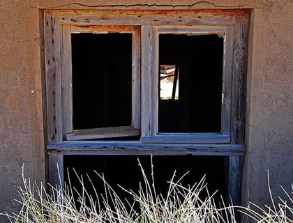 Fensteröffnung mit Blick in die Wüste, Grasbüschel davor