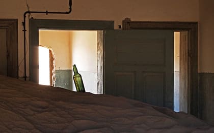 Langer Raum mit Sand und Türen, grüne Wände