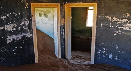 Blau gestrichene Wände, Türrahmen und Sand
