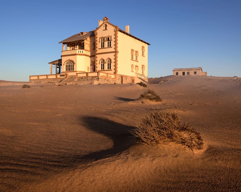 Villa in Kolmanskop im warmen Abendlicht, Dünen im Vordergrund